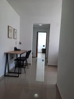 a dining room with a table and chairs and a hallway at Departamento en Nueva Córdoba in Cordoba