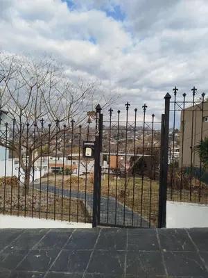 a iron fence with a gate in front of a building at Chalet 