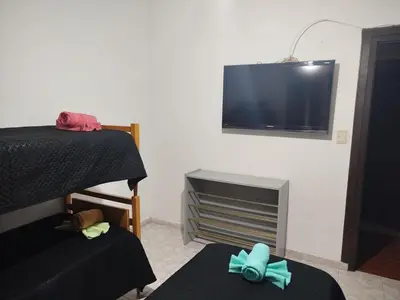 a room with two beds and a tv on the wall at Chalet 