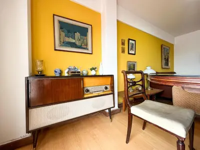 a living room with a dresser and a chair and a piano at Amplio Piso Vintage, Terraza con Vista a Sierras in Cordoba