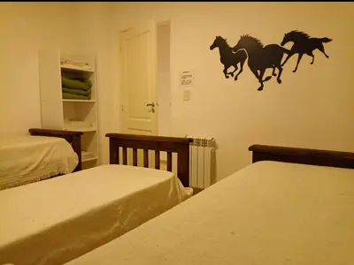 a bedroom with two beds and a mural of horses on the wall at Apartamentos Santa Rosa PB3 in Cordoba