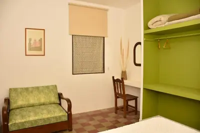 a green room with a chair and a shelf at Casa Sarmiento in San Francisco del Monte de Oro