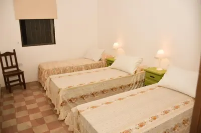 a room with three beds and a chair in it at Casa Sarmiento in San Francisco del Monte de Oro
