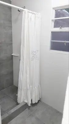a white shower curtain in a bathroom with a window at Casa Sarmiento in San Francisco del Monte de Oro