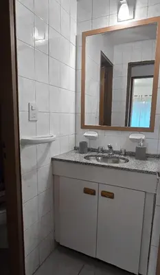 a white bathroom with a sink and a mirror at CHACABUCO 1 dormitorio in Cordoba