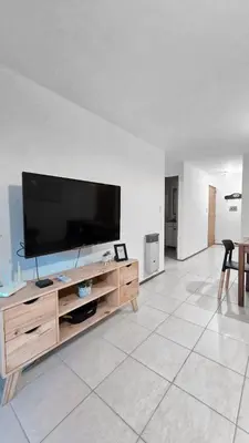 a living room with a flat screen tv on a wooden entertainment center at CHACABUCO 1 dormitorio in Cordoba
