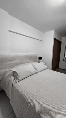 a white bedroom with a large white bed in it at CHACABUCO 1 dormitorio in Cordoba