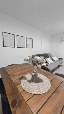 a living room with a wooden table with a vase of flowers at CHACABUCO 1 dormitorio in Cordoba