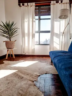 a living room with a blue couch and a window at DPTO ZONA PATIO OLMOS in Cordoba