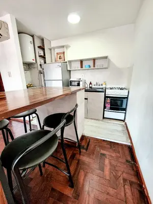 a kitchen with a counter and two chairs in it at DPTO ZONA PATIO OLMOS in Cordoba