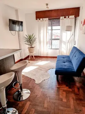 a living room with a blue couch and a stool at DPTO ZONA PATIO OLMOS in Cordoba