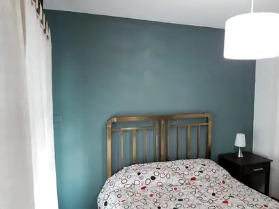 a bed in a bedroom with a blue wall at DPTO ZONA PATIO OLMOS in Cordoba