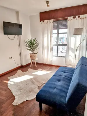 a living room with a blue couch and a tv at DPTO ZONA PATIO OLMOS in Cordoba