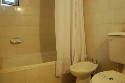 a bathroom with a toilet and a tub and a sink at Cabañas Am Hang in La Cumbrecita