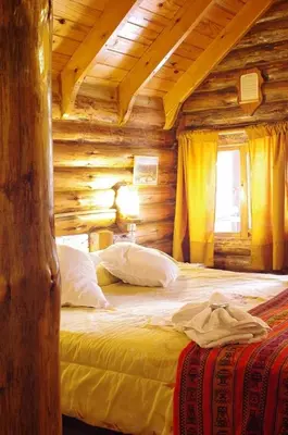 a bedroom with a bed in a log cabin at Cabañas Am Hang in La Cumbrecita