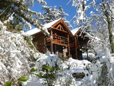 a log cabin covered in snow at Cabañas Am Hang in La Cumbrecita