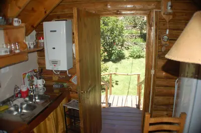 a kitchen with a door leading to a porch at Cabañas Am Hang in La Cumbrecita