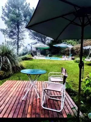 a table and two chairs and an umbrella on a deck at Akapana Suites in La Cumbrecita