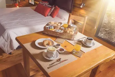 a tray of breakfast food on a table in a bedroom at Akapana Suites in La Cumbrecita