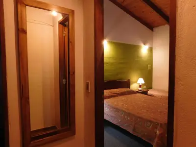 a room with a bedroom with a bed and a mirror at El Agora in Villa General Belgrano