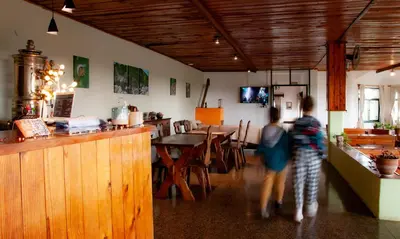 two people walking through a restaurant with a bar at Hotel Panorama in La Cumbrecita