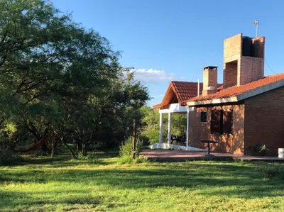 an old brick house in a field with a tree at Tacko Huasi in San Javier