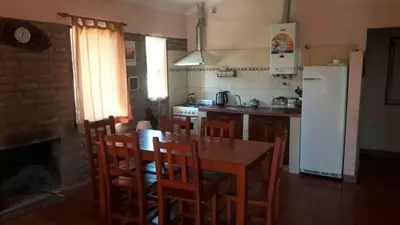 a kitchen with a table and chairs and a refrigerator at Tacko Huasi in San Javier