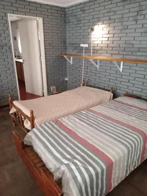 two beds in a bedroom with a brick wall at Confortable en Cofico in Cordoba