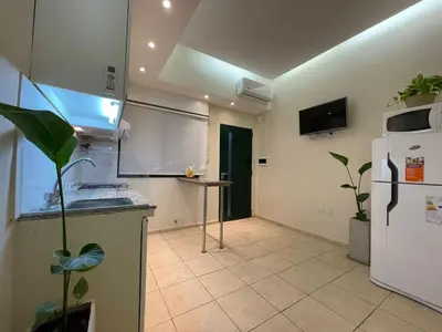 a kitchen with a white refrigerator and a tile floor at La Escalerita- Estadio Kempes in Cordoba