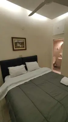 a large bed with white pillows in a bedroom at La Escalerita- Estadio Kempes in Cordoba