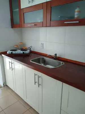 a kitchen with white cabinets and a sink at Casita Misol con piscina exclusiva y 100 mts del rio in Villa Carlos Paz