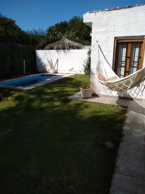 a yard with a hammock in front of a house at Casita Misol con piscina exclusiva y 100 mts del rio in Villa Carlos Paz
