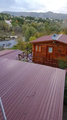 a wooden cabin with a large metal roof at Cabañas La Escondida Casa De campo in San Antonio de Arredondo