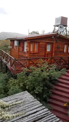 a wooden cabin with a staircase leading to it at Cabañas La Escondida Casa De campo in San Antonio de Arredondo