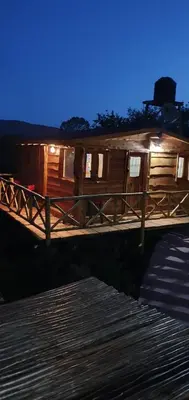 a wooden cabin on a dock at night at Cabañas La Escondida Casa De campo in San Antonio de Arredondo