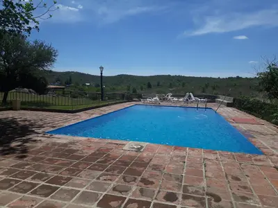 a swimming pool with blue water in a yard at Cabañas La Escondida Casa De campo in San Antonio de Arredondo
