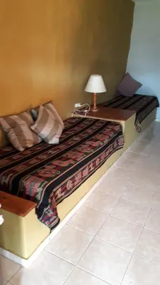 a bedroom with a bed with a lamp on a table at Cabañas La Escondida Casa De Campo 2 in San Antonio de Arredondo