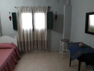 a bedroom with a bed and a window with curtains at Cabañas La Escondida Casa De Campo 2 in San Antonio de Arredondo