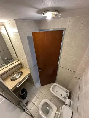 a small bathroom with a toilet and a sink at Apart Hotel Bari in Cordoba