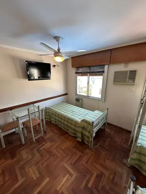 a room with a bed and a flat screen tv at Apart Hotel Bari in Cordoba