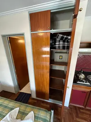 a small kitchen with a cupboard in a room at Apart Hotel Bari in Cordoba