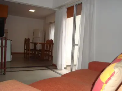 a living room with a couch and a kitchen with a table at Departamento Andino in Río Cuarto
