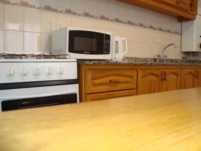 a kitchen with a white stove and a microwave at Departamento Andino in Río Cuarto
