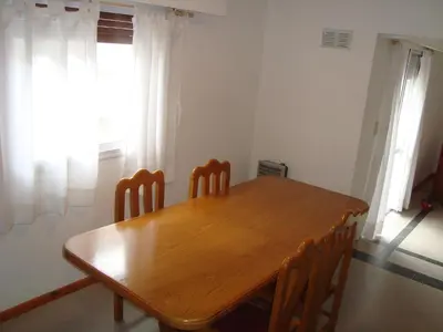 a wooden table and chairs in a room at Departamento Andino in Río Cuarto