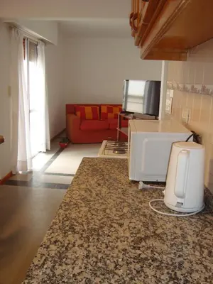a living room with a microwave and a couch at Departamento Andino in Río Cuarto