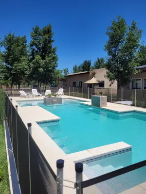 a swimming pool with blue water in a yard at Complejo Boulevard in Villa Ciudad de America