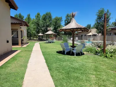 a yard with a table and chairs and an umbrella at Complejo Boulevard in Villa Ciudad de America