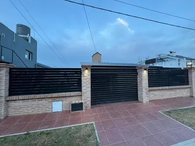 a brick retaining wall with a gate on a building at Casa Paz in Villa Carlos Paz