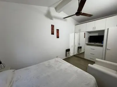 a white bedroom with a bed and a ceiling fan at Casa Paz in Villa Carlos Paz