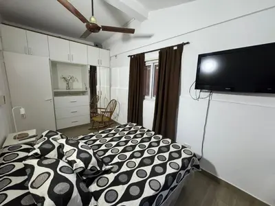a bedroom with a bed and a flat screen tv at Casa Paz in Villa Carlos Paz